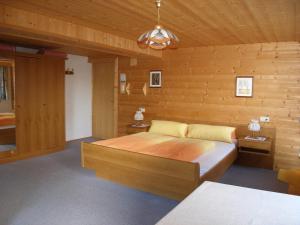 ein Schlafzimmer mit einem Bett und einer Holzwand in der Unterkunft Gästehaus Dorer Gerhard in Prägraten