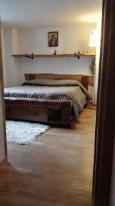 - une chambre avec un lit avec une étagère sur le mur dans l'établissement Appartamento in La Thuile località Thovex, à La Thuile