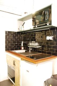 La cuisine est équipée d'un évier et d'un four micro-ondes. dans l'établissement Arty 20m² district of BATIGNOLLES, à Paris