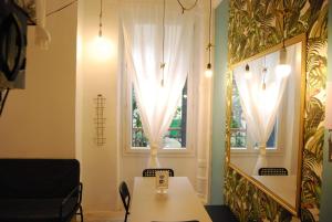 パリにあるArty 20m² district of BATIGNOLLESのテーブルとカーテン付きの窓が備わる客室です。
