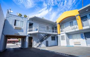 um edifício branco e amarelo com estacionamento em Value Inn Hollywood em Los Angeles