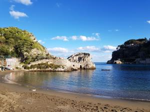 タオルミーナにあるTaoApartments - Casa Salinaの海中の岩を望むビーチの景色