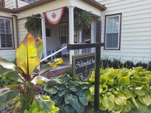 a sign in a garden in front of a house at Hellemsfield Inn & bed and breakfast in Kingsville