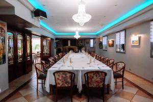 a dining room with a long table and chairs at Logis Hotels - Hotel Restaurant l Enclos in Donneville