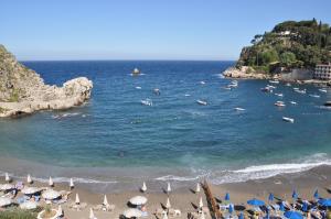 a beach with umbrellas and people swimming in the ocean at TaoApartments - Casa Salina in Taormina
