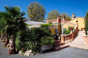 a house with a deck and a staircase leading to it at Logis Hotels - Hotel Restaurant l Enclos in Donneville