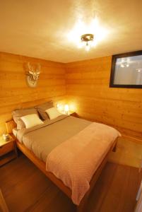 1 dormitorio con 1 cama en una habitación de madera en Appartement 25m2 à Saint-Gervais les bains en Saint-Gervais-les-Bains
