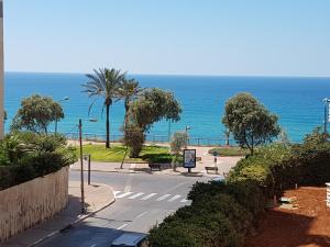 una calle vacía con el océano en el fondo en Nitza Boutique Apartment Kosher, en Netanya