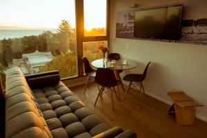 ein Wohnzimmer mit einem Sofa und einem Tisch in der Unterkunft Own Montevideo in Montevideo