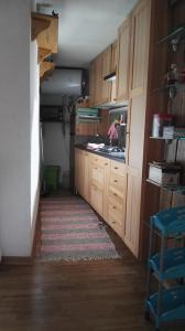 une cuisine avec des placards en bois et un tapis dans l'établissement Appartamento in La Thuile località Thovex, à La Thuile