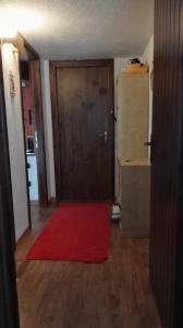Cette chambre dispose d'une porte et d'un tapis rouge. dans l'établissement Appartamento in La Thuile località Thovex, à La Thuile