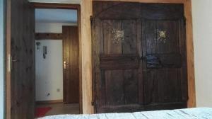 - une grande porte en bois dans une chambre avec un lit dans l'établissement Appartamento in La Thuile località Thovex, à La Thuile