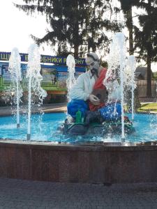 a man sitting in front of a fountain at Hotel Yuvileyny in Khrystynivka