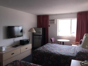 a hotel room with two beds and a television at DC Lodge in Dawson Creek