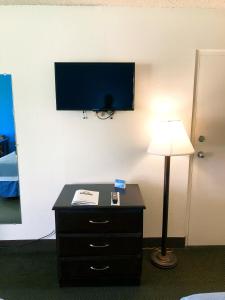 a desk with a television and a lamp on top of it at One Way Maingate in Kissimmee