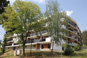 an apartment building with trees in front of it at Rezidencia AMÉLIA - Apartmán SOFIA in Bardejovské Kúpele