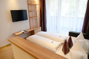 ein Hotelzimmer mit einem Bett und einem TV in der Unterkunft Birkheim in Ischgl
