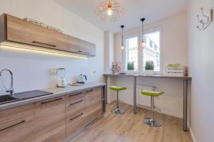 a kitchen with a sink and two green stools at Mariacka1 in Szczecin