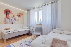 a bedroom with two beds and a picture of a girl at Mariacka1 in Szczecin