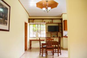 a kitchen with a table and chairs and a television at Apart Hotel Acuarious de Luis in Estelí