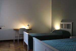 a bedroom with two beds and a desk and a table at B & B Da Matilde in Bologna