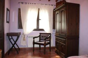 een slaapkamer met een stoel en een raam bij Apartamento El Carro - La Xiarapina in Serrapio