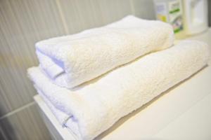 two white towels sitting on a shelf in a bathroom at Apartment Sea Breeze in Fontanka