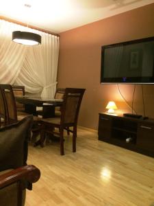 a living room with a table and a flat screen tv at Apartament ''Cleopatra'' z garazem podziemnym, faktury VAT in Kielce