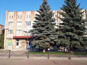 two pine trees in front of a building at Hotel Yuvileyny in Khrystynivka