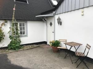 uma mesa e cadeiras em frente a uma casa branca em Bed & Breakfast Höllviken em Höllviken