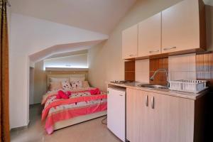 a small bedroom with a bed and a sink at Vila Tea Petrusevski in Ohrid