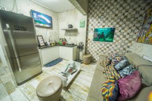 uma sala de estar com um sofá e um frigorífico em Galinha d'Angola em Porto de Galinhas