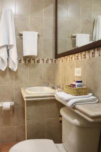 W łazience znajduje się umywalka, toaleta i lustro. w obiekcie Hotel Solaris w mieście Turbo
