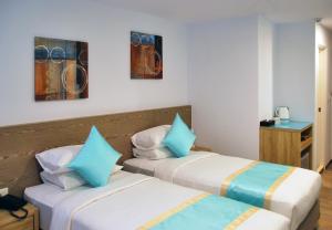 two beds in a hotel room with blue at Palau Hotel in Koror
