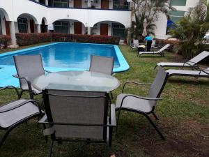 a table and chairs next to a swimming pool at Best Western Global Express in Veracruz