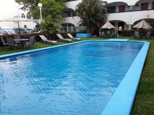 a large blue swimming pool in front of a building at Best Western Global Express in Veracruz