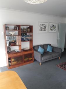 a living room with a couch and a table at Our Raglan Town House in Raglan