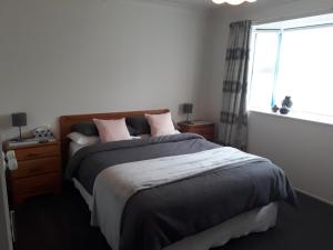 a bedroom with a large bed and a window at Our Raglan Town House in Raglan