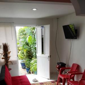 un soggiorno con divano rosso e TV di Vianova's Place Posada Nativa a San Andrés
