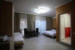 a hotel room with two beds and a mirror at Hotel Okriba Tbilisi in Tbilisi City