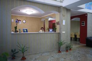 a woman sitting at a counter in a waiting room at Hotel Okriba Tbilisi in Tbilisi City