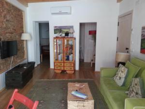 a living room with a green couch and a table at Casa da Rua Nova in Castelo de Vide