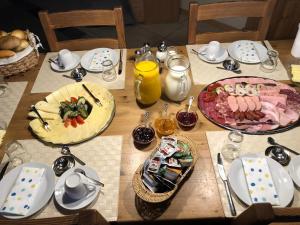 a wooden table with plates of food on it at Pension Pung in Herresbach