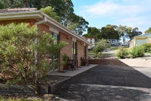 a brick house with chairs outside of it at Bega Caravan Park in Bega
