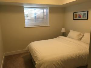 sypialnia z białym łóżkiem i oknem w obiekcie Albion Stay w mieście Maple Ridge District Municipality