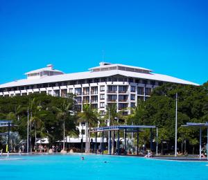 a building with a swimming pool in front of it at Mantra Esplanade in Cairns