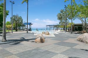 a park with palm trees and the ocean in the background at Mantra Esplanade in Cairns