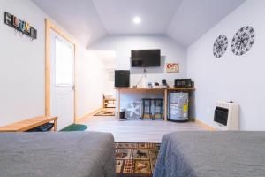 1 dormitorio con 2 camas, escritorio y TV en Cache Cabins, en Sunshine