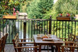a wooden table with two chairs on a deck at The Watermill Hotel, Sure Hotel Collection by Best Western in Hemel Hempstead
