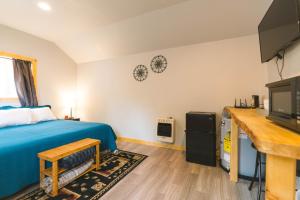 ein Schlafzimmer mit einem blauen Bett und einem TV in der Unterkunft Cache Cabins in Sunshine
